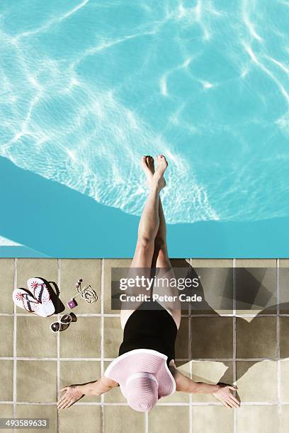 middle aged woman relaxing at edge of pool - pés cruzados - fotografias e filmes do acervo