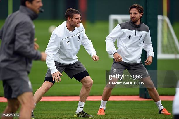 Liverpool's English midfielder James Milner and Liverpool's Welsh midfielder Joe Allen stretch during a team training session in Liverpool, northwest...