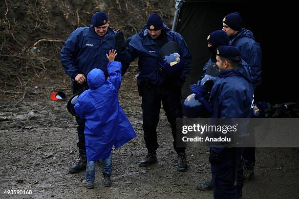 Serbian police talk to a refugee girl as the refugees who crossed the Macedonia - Serbia border try to reach Berkasovo town on the Serbia - Croatia...