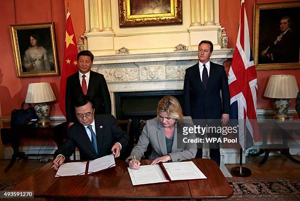 Britain's International Development Secretary Justine Greening and China's Minister of Commerce Gao Hucheng sign an agreement as Britain's Prime...