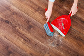 Cleaning woman sweeping wooden floor