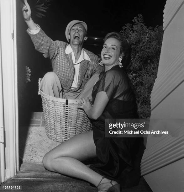 Actor John Carradine sits in a basket with wife Sonia Sorel before the party at home in Los Angeles, California.