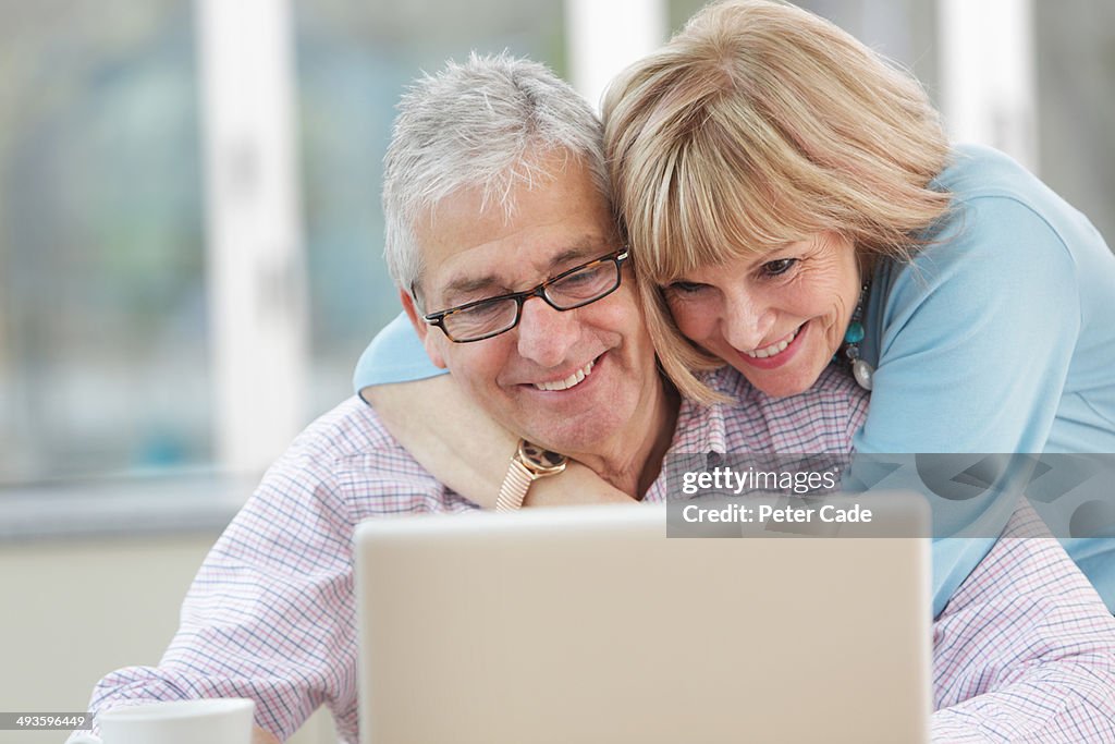 Older couple looking at laptop, happy