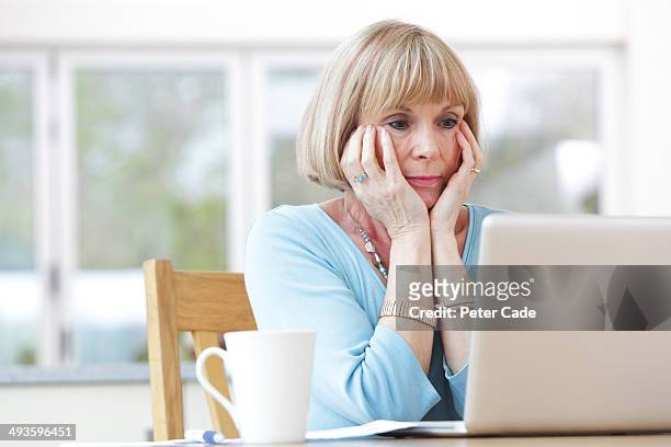 woman looking concerned at laptop - woman worried bildbanksfoton och bilder