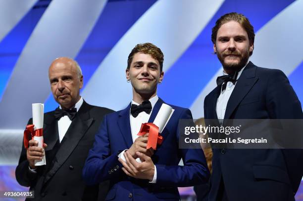 Producer Alain Sarde and director Xavier Dolan pose on stage with actor Daniel Bruhl after jointly winning the Jury Prize for 'Mommy' and 'Adieu au...