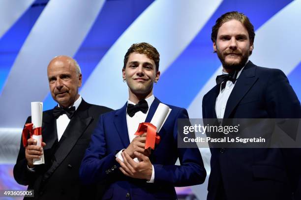 Director Xavier Dolan and producer Alain Sarde pose with actor Daniel Bruhl after being awarded with the Jury Prize for "Mommy" and "Adieu au...