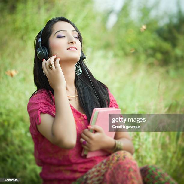 happy young woman listening music in nature. - indian music 個照片及圖片檔