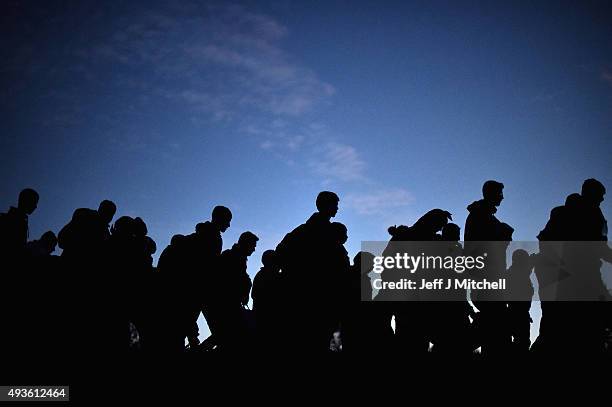 Migrants cross into Slovenia at night on October 21, 2015 near the village of Dobova, Slovenia. Migrants are escorted by police and soldiers after...