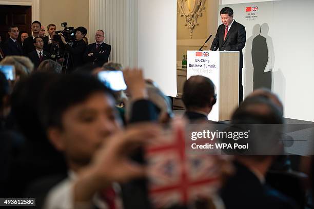 Guests and delegates take photos and videos as President of the People's Republic of China Xi Jinping delivers a speech at the UK-China Business...