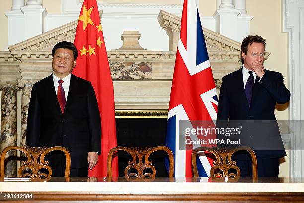 British Prime Minister David Cameron stands with the President of the People's Republic of China Xi Jinping during a commercial contract exchange at...