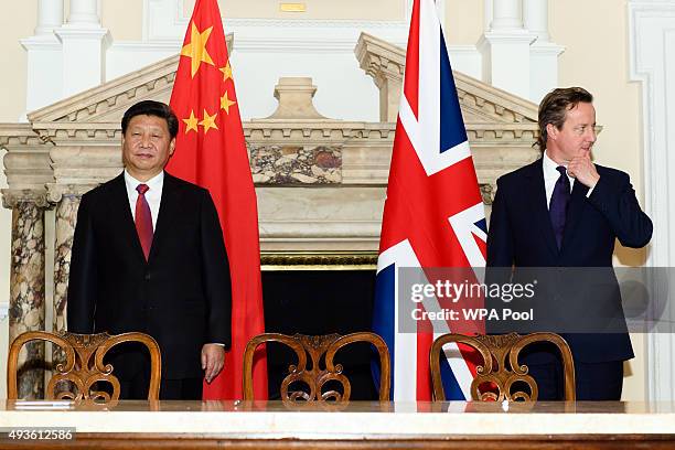 British Prime Minister David Cameron stands with the President of the People's Republic of China Xi Jinping during a commercial contract exchange at...