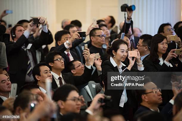 Guests and delegates take photos and videos as the Chinese president delivers a speech at the UK-China Business Summit in Mansion House on October...