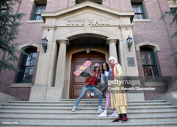 Mike Knell, dressed as the character Dr. Emmett Brown, Stephanie Knell and Jackie Peters pose on steps of Hill Valley Courthouse Square in the back...