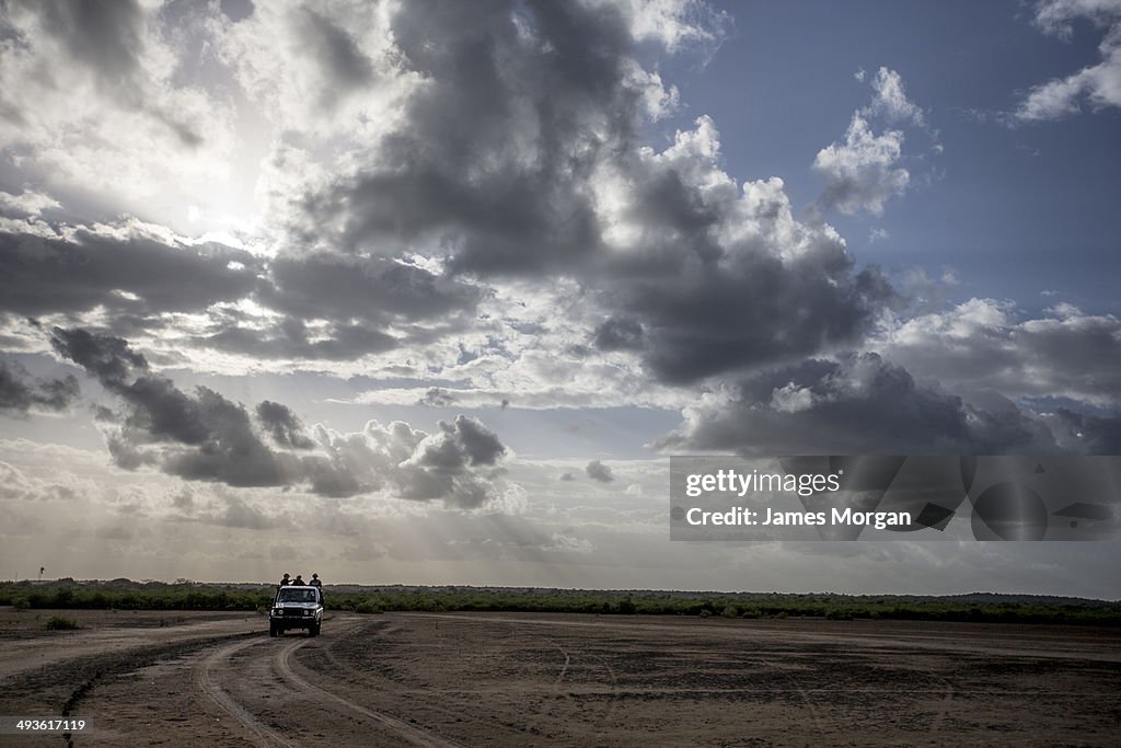 Truck in dirt clearing with cloudscape