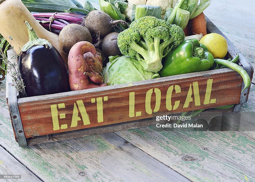 "Eat local" printed on a crate of vegetables