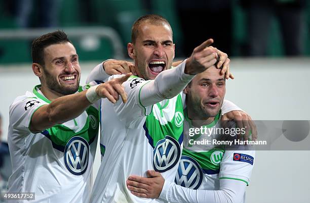 Bas Dost of Wolfsburg celebrates after scoring his team's opening goal with Daniel Caligiuri of Wolfsburg and Christian Traesch of Wolfsburg during...
