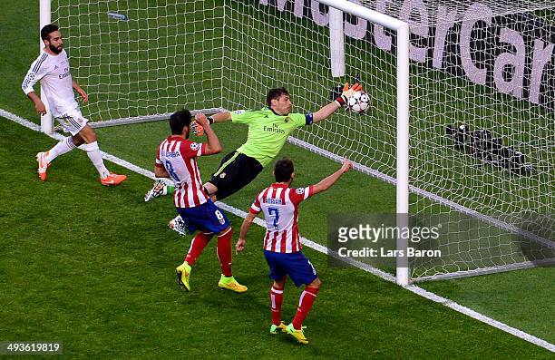 Iker Casillas of Real Madrid fails to stop the ball headed in by Diego Godin of Club Atletico de Madrid for the first goal during the UEFA Champions...