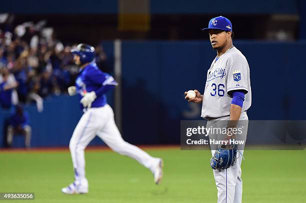 Edinson Volquez of the Kansas City Royals reacts as Chris Colabello of the Toronto Blue Jays runs the bases after hitting a solo home run in the...