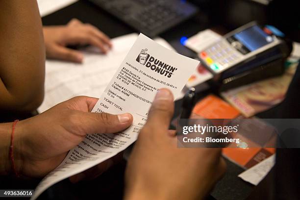 Worker reviews a customer's order during the opening of the new Dunkin' Donuts Inc. Restaurant in Mexico City, Mexico, on Wednesday, Oct. 21, 2015....