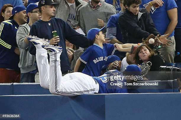 Chris Colabello of the Toronto Blue Jays is unable to catch a foul ball hit by Salvador Perez of the Kansas City Royals in the third inning during...