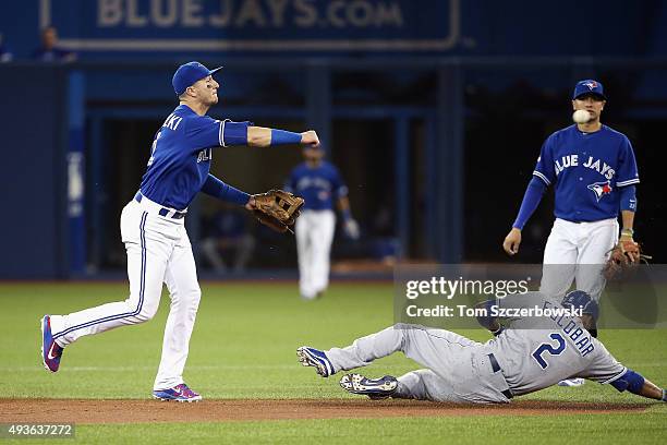 Troy Tulowitzki of the Toronto Blue Jays turns a double play over Alcides Escobar of the Kansas City Royals in the fourth inning during game five of...