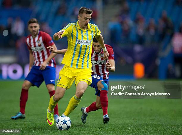 Aleksei Schetkin of FC Astana competes for the ball ahead Yannick Carrasco of Atletico de Madrid and his teammate Guilherme Madalena Siqueira during...