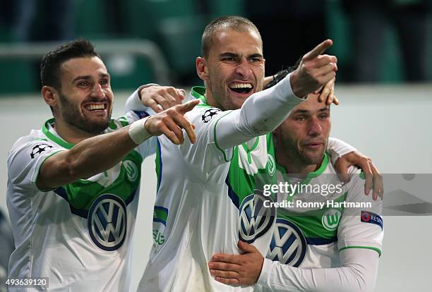 Bas Dost of Wolfsburg celebrates after scoring his team's opening goal with Daniel Caligiuri of Wolfsburg and Christian Traesch of Wolfsburg during...