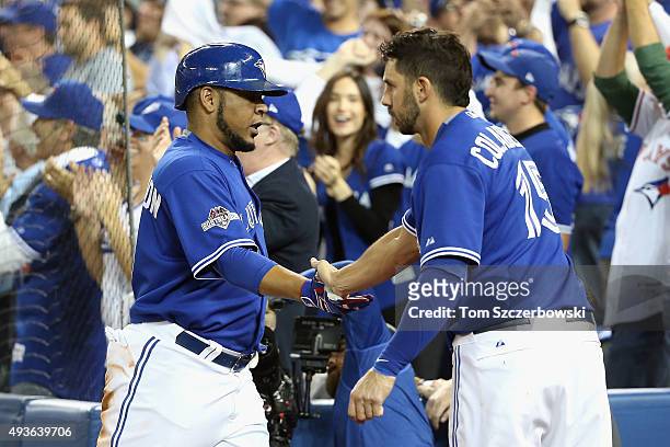 Edwin Encarnacion of the Toronto Blue Jays is congratulated by Chris Colabello of the Toronto Blue Jays after scoring a run in the sixth inning...