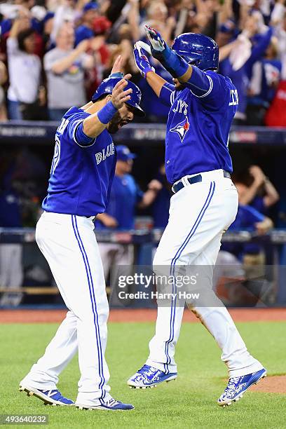 Jose Bautista of the Toronto Blue Jays celebrates with Edwin Encarnacion of the Toronto Blue Jays after they both score runs in the sixth inning...