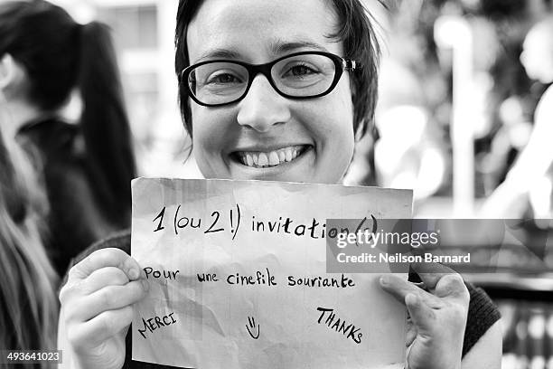 Film fans wait outside the Palais des Festivals holding signs in the hope of getting a ticket to one of the many films showing during the 67th Annual...