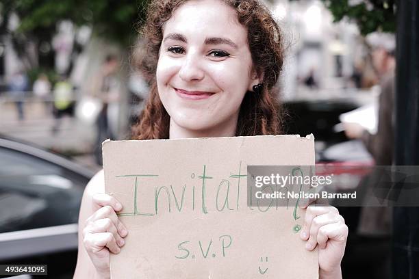 Film fans wait outside the Palais des Festivals holding signs in the hope of getting a ticket to one of the many films showing during the 67th Annual...