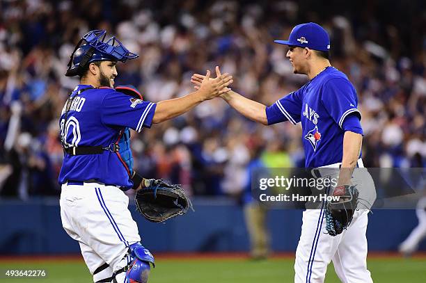 Roberto Osuna of the Toronto Blue Jays celebrates a 7-1 win over the Kansas City Royals with Dioner Navarro of the Toronto Blue Jays during game five...