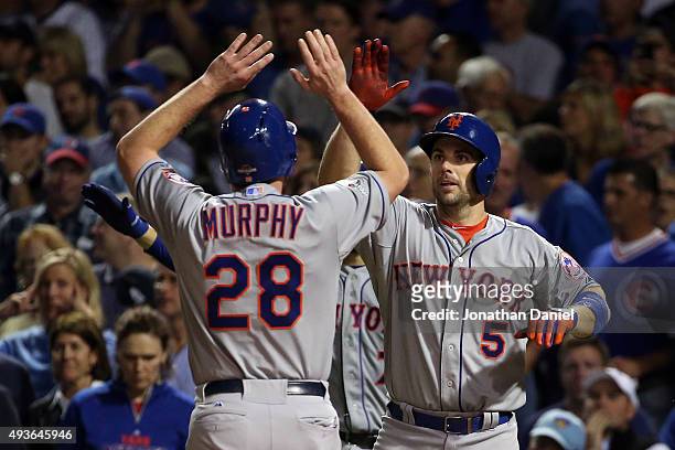 Daniel Murphy and David Wright of the New York Mets celebrate after scoring off of a double hit by Lucas Duda of the New York Mets in the second...