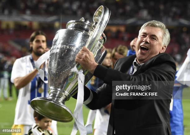 Real Madrid's Italian coach Carlo Ancelotti celebrates their victory with the trophy at the end of the UEFA Champions League Final Real Madrid vs...