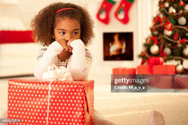 sad little girl with christmas present - bad gift stock pictures, royalty-free photos & images
