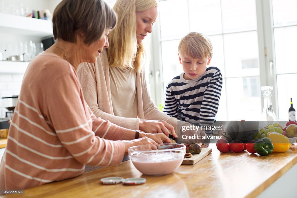 Mujer joven con su Madre e hijo cocinar alimentos