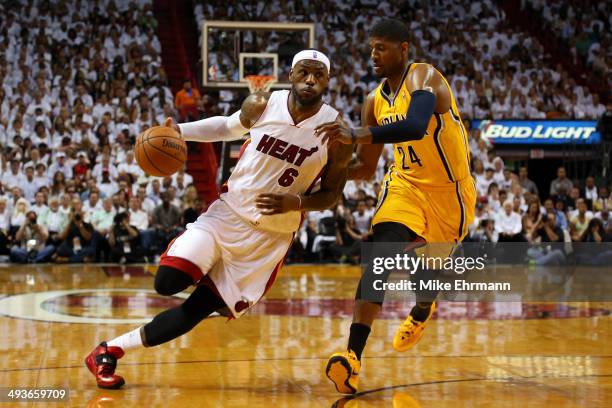 LeBron James of the Miami Heat drives to the basket against Paul George of the Indiana Pacers in the first period during Game Three of the Eastern...