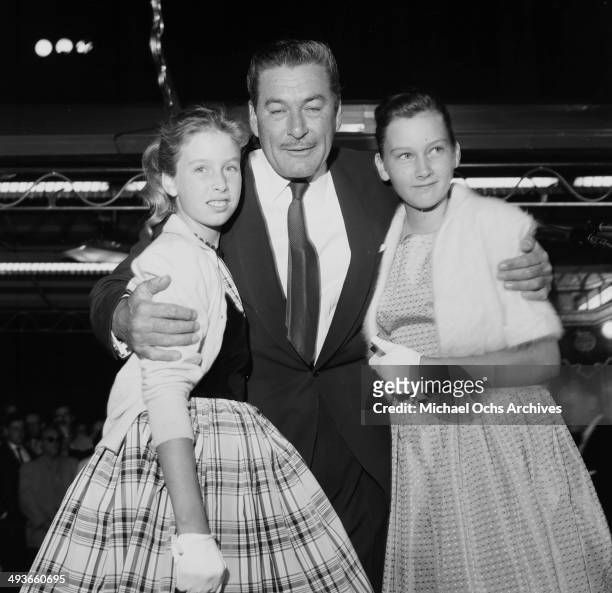 Actor Errol Flynn poses with daughters Deidre 12 and Rory 10 at the premier of "My Man Godfrey: in Los Angeles, California.