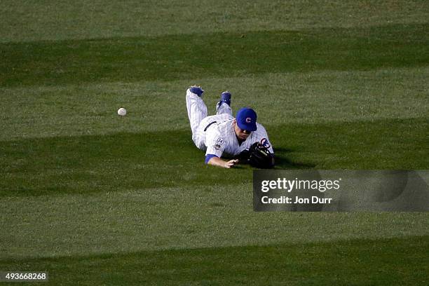 Kyle Schwarber of the Chicago Cubs misses a catch hit by Wilmer Flores of the New York Mets in the first inning during game four of the 2015 MLB...