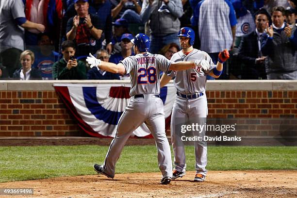 Daniel Murphy of the New York Mets celebrates with David Wright after hitting a two run home run in the eighth inning against the Chicago Cubs during...