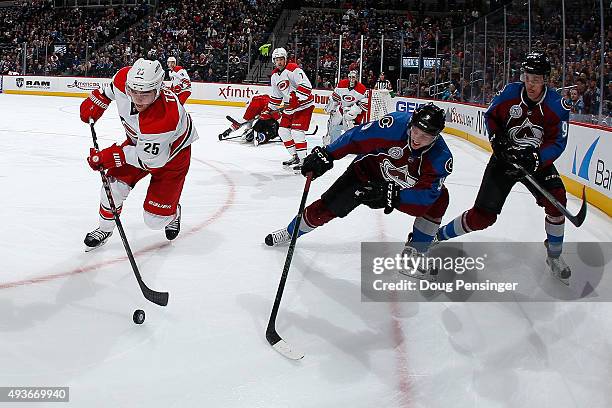 Chris Terry of the Carolina Hurricanes controls the puck against Matt Duchene and Mikko Rantanen of the Colorado Avalanche at Pepsi Center on October...