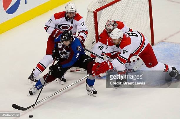 Matt Duchene of the Colorado Avalanche tries to regain possession of the puck while Jordan Staal , Cam Ward and Ron Hainsey of the Carolina...