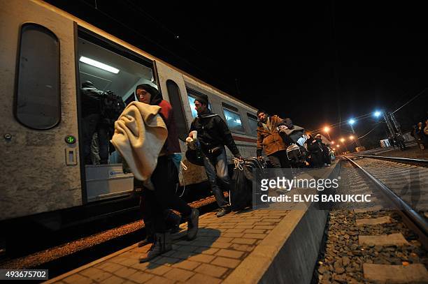 Migrants board train in the eastern Croatian town of Tovarnik late on October 21, 2015 as migrants and asylum seekers try to reach the Slovenian...