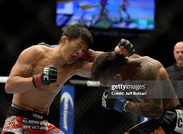 Takeya Mizugaki punches Francisco Rivera in their bantamweight bout during the UFC 173 event at the MGM Grand Garden Arena on May 24, 2014 in Las...