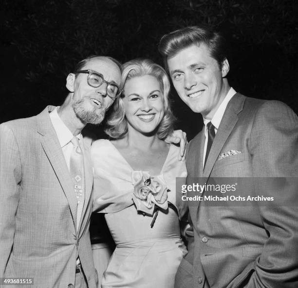 Actor Edd Byrnes with his wife actress Asa Maynor pose with photographer Earl Leaf at a party in Los Angeles, California.