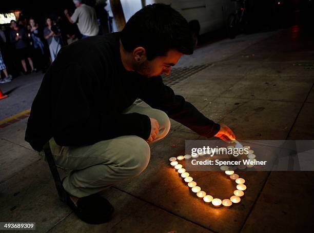 Santa Barbara student Eldar Erlich lights candles at a growing memorial in front of the IV Deli Mart on Pardall Road in Isla Vista on May 24, 2014 in...