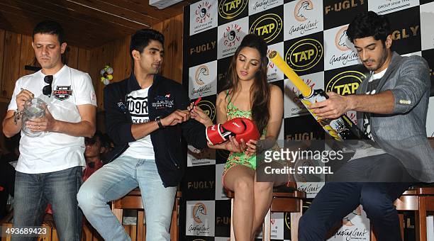Indian Bollywood actors Vijender Singh , Kiara Advani and Mohit Marwah sit onstage during a promotional event for the forthcoming Hindi film F*UGLY...