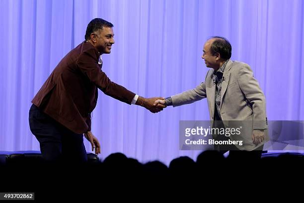 Billionaire Masayoshi Son, chairman and chief executive officer of SoftBank Group Corp., right, shakes hands with Nikesh Arora, president and chief...