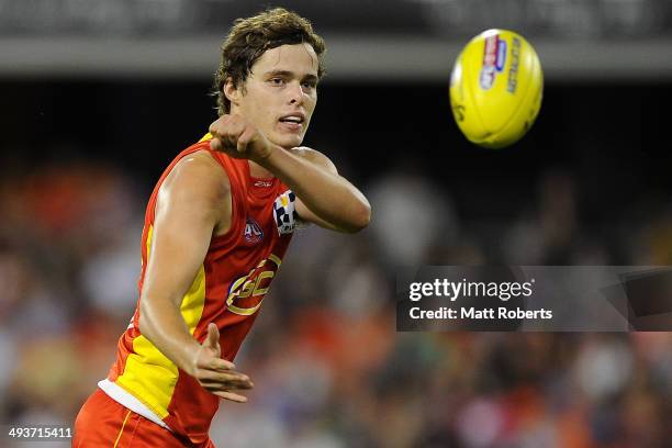 Kade Kolodjashnij of the Suns handballs during the round 10 AFL match between the Gold Coast Suns and the Western Bulldogs at Metricon Stadium on May...