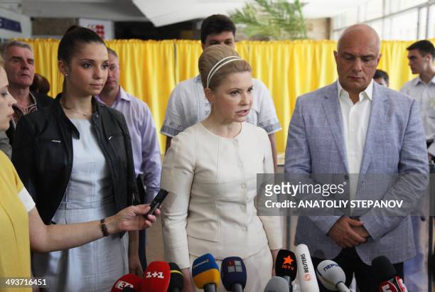 Ukrainian presidential candidate Yulia Tymoshenko speaks to journalists after casting her ballot, alongside her daughter Yevhenia and her husband...